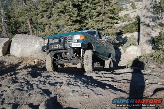 Green Ford Bronco on rocky trail, front winch visible. License plate 52FW128