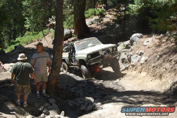 Light-colored off-road SUV navigating a steep, rocky trail