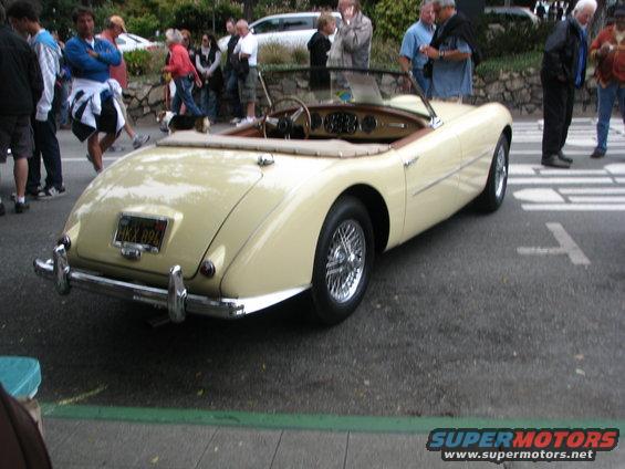 Cream-colored convertible with wire wheels and a license plate reading HKX 894