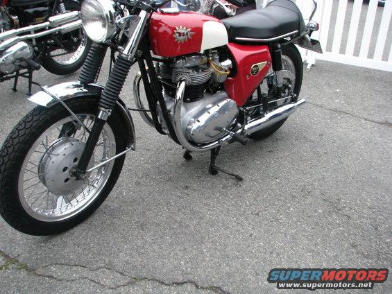 Red and white BSA motorcycle with chrome accents, parked on asphalt