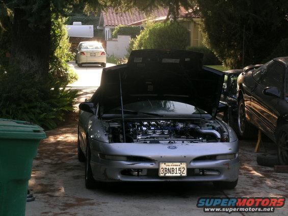 Silver 1995 Ford Probe with hood open, showing engine bay. Front view