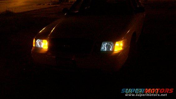 Front of car with illuminated headlights at night