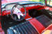 1959 Ford Ranchero - The interior of a 1959 Ford Ranchero features a red dashboard, black seats with red accents, and a custom steering wheel.