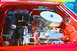 1959 Ford Ranchero - The engine bay of a red car features a polished V8 engine with custom chrome components.