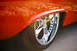 1959 Ford Ranchero - Close-up of a 1959 Ford Ranchero's orange paint and chrome wheel.