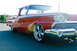 1959 Ford Ranchero - A red pickup truck is shown from a low angle, highlighting its chrome wheels and custom front end.