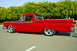 1959 Ford Ranchero - Side view of a red 1959 Ford Ranchero with custom wheels and lowered suspension.