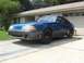 1989 Ford Mustang - A blue 1989 Ford Mustang with black wheels sits in a driveway.