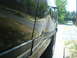 1988 Ford Bronco - Side view of a black SUV with significant damage to the body panel.
