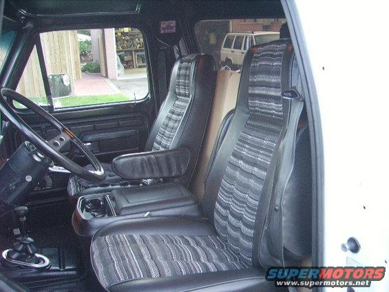 1978 Ford Bronco interior showing front seats, steering wheel, and center console. Another SUV is visible through the window