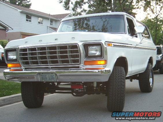 White 1978 Ford Bronco with a chrome grille and a "BIG LOG" license plate, viewed from the front