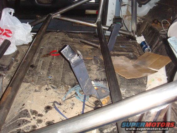 Interior roll cage with seatbelt buckle and debris on floor