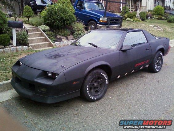 Matte black 1989 Chevrolet Camaro with racing stripes on side