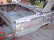 1964 Ford Fairlane - The rear section of a car is visible, with the trunk open and the body in a state of repair.