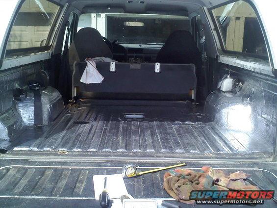 1994 Ford Bronco interior showing the bed with sound deadening material and a folded rear seat