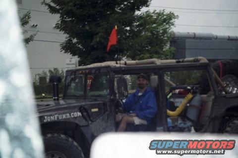 Off-road vehicle with snorkels, red flag, and "JONFUND.COM" text