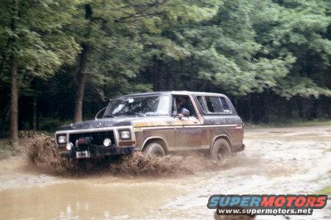 Ford Bronco driving through mud, splashing water