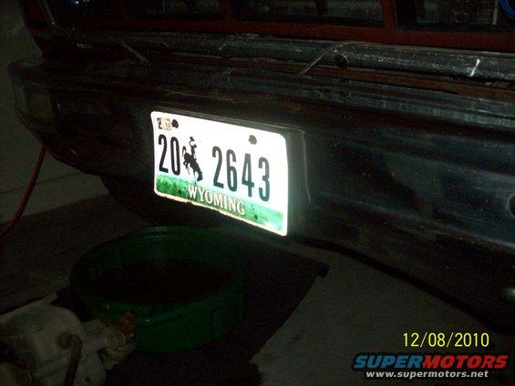 Rear bumper of a vehicle with a Wyoming license plate reading 20 2643. A green drain pan is underneath