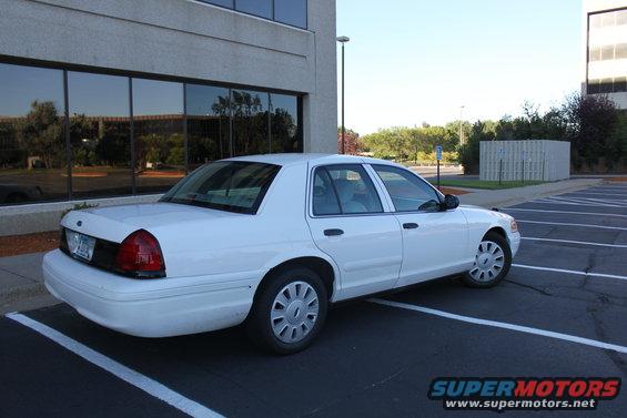 White sedan parked in a lot, rear view