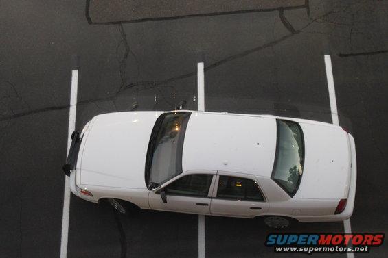 White 2003 Ford Crown Victoria parked in a lot, viewed from above