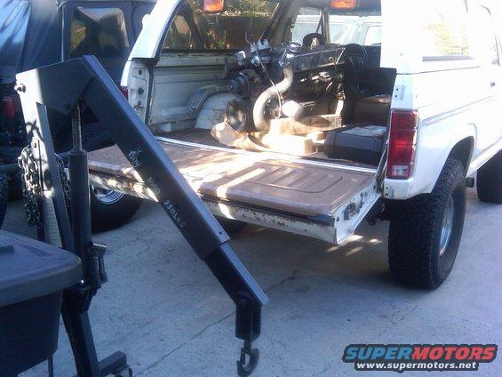 White 1986 Ford Bronco rear view with engine removed and hoist in bed. Text on hoist reads '1500 750LBS'