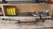 1968 Ford Ranchero - Various steering linkage components are displayed on a workbench alongside tools and yellow oil bottles.