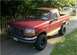 1994 Ford Bronco - This 1994 Ford Bronco is parked on a driveway with a wooden fence and some greenery in the background.