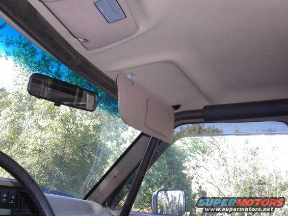 Interior view of a vehicle with a sun visor and rearview mirror