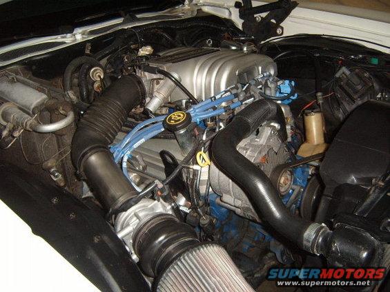 Engine bay showing V8 engine, air intake, and hoses