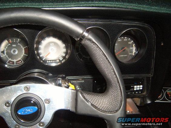 Dashboard of a 1973 Ford Ranchero with a blue Ford emblem on the steering wheel, fuel gauge, speedometer, and tachometer visible
