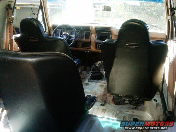 Interior view of a 1986 Ford Bronco with racing seats and a manual transmission