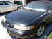 1992 Ford Taurus - The front end of a black 1992 Ford Taurus is visible, parked next to another vehicle.
