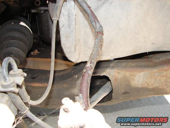Rusty wiring harness and suspension parts on vehicle underside