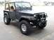 1979 Jeep CJ7 - This Jeep CJ features a tan soft top and an aftermarket front bumper with a winch, indicating a later model year than 1979.