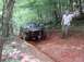 1995 Ford Bronco - A 1992-1996 Ford Bronco navigates a muddy, wooded trail, with one wheel deep in the mire.