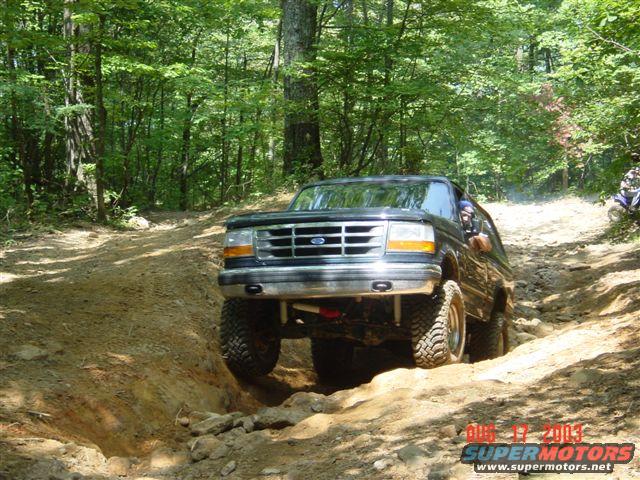 Black 1995 Ford Bronco navigating a rocky off-road trail