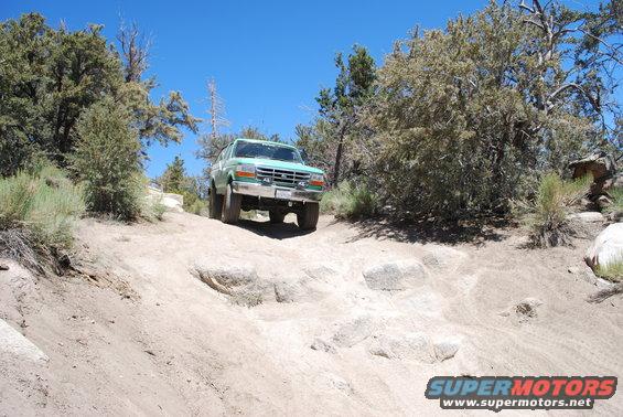 Green 1996 Ford Bronco on a rocky off-road trail