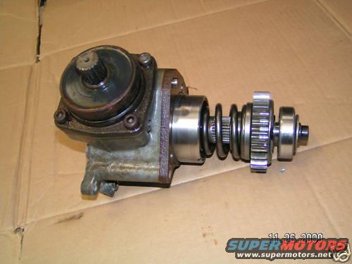 Motorcycle starter drive assembly with gears and spring on cardboard