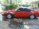 1989 Ford Mustang - Side view of a red 1989 Ford Mustang coupe with aftermarket wheels.