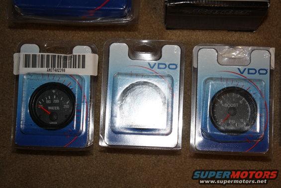 Three VDO automotive gauges in packaging: water temperature, blank, and boost pressure
