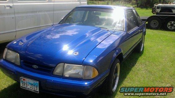 Blue coupe with aftermarket hood scoop and custom hood pins