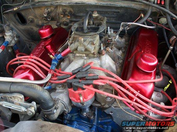 Close-up of a V8 engine with red valve covers and spark plug wires