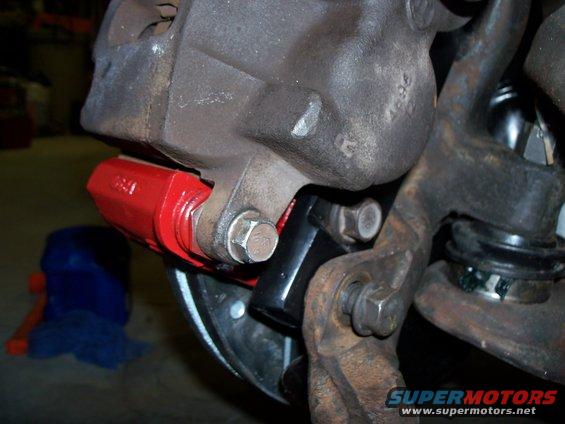 lower-caliper-bracket-to-ranchero-spindle.jpg This shows the lower spindles bracket mounting hole and the welded spacer 1/4" additional to 3/8" bracket both were tapped for 1/2"-13 lower bolt. The caliper bracket to spindle bracket bolt can be removed without removing the spindle bracket, it just misses the Ranchero spindle. The bolts used to hold the caliper bracket(black bracket) to spindle are the Ranchero's original bracket bolts. The caliper to spindle bracket(red bracket) bolts, 18mm, are from a donor Crown Vic.