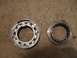 1996 Ford Bronco - Two metal bearing parts are shown on a textured surface.