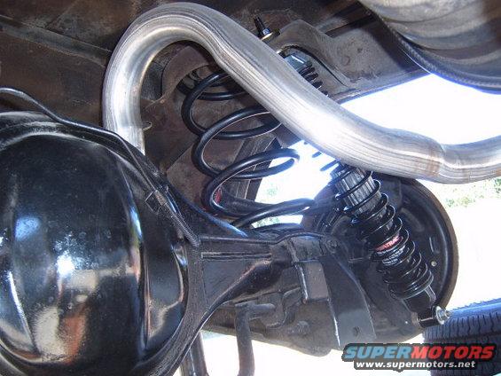 Rear suspension with coil spring, shock absorber, differential, and exhaust pipe
