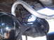 1973 Ford Ranchero - Close-up view of the rear suspension components and exhaust system, including a coil spring and shock absorber.