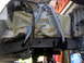 1996 Ford Bronco - Close-up view of vehicle frame and suspension components, some parts are masked off with paper and tape.