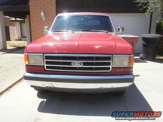 Front view of a red Ford pickup truck with a chrome bumper and grille. It has 4x4 badging