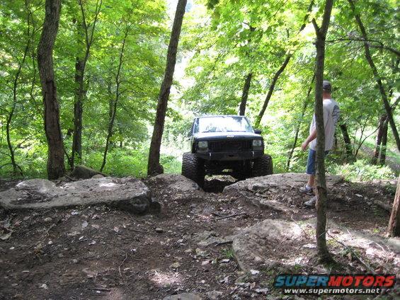 Modified Jeep Cherokee XJ with large tires on a rocky trail