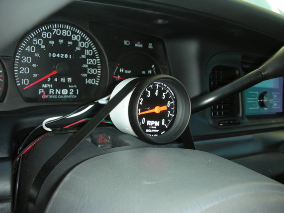 Dashboard interior of a 2004 Ford Crown Victoria with an aftermarket tachometer installed